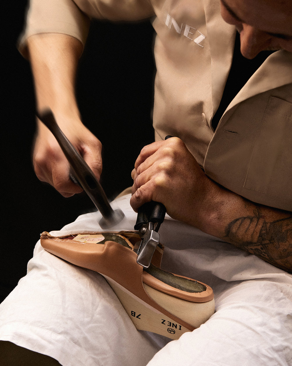 An artisan hammering the heel of an Inez shoe by hand